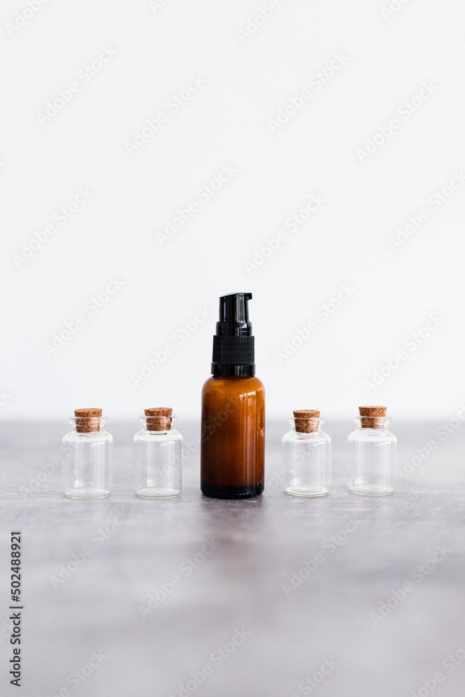 natural beauty and organic ingredients in skincare, amber skincare bottle with small bottles of ingredients next to it natural beauty and organic ingredients in skincare, amber skincare bottle with small bottles of ingredients next to it