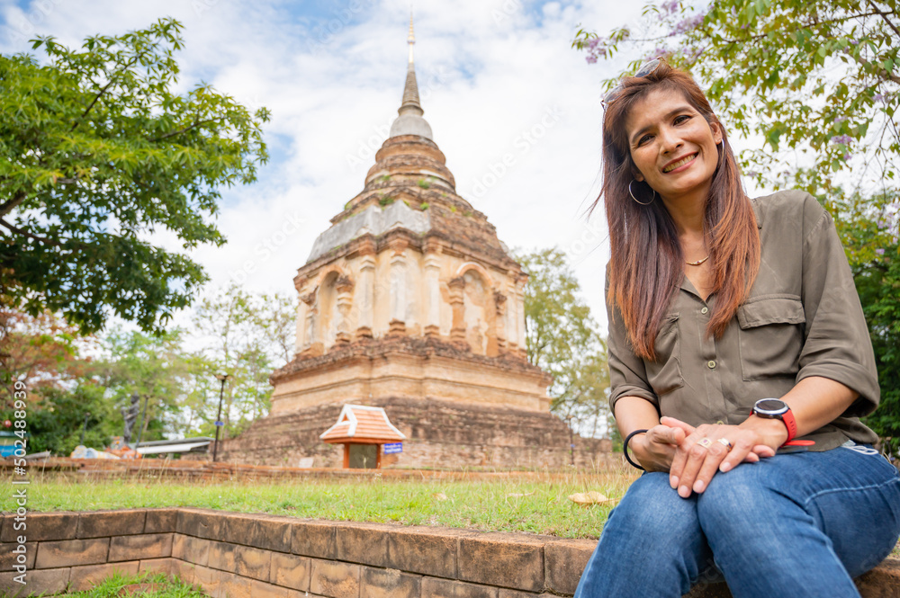 Thai woman with Lanna archaeological background at Wat Chet Yod in Chiang Mai province