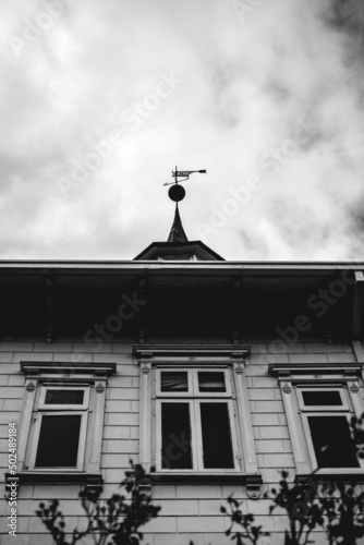 Beautiful windows and tower with compass rose in a old centuries building with neoclassical architecture and ornaments in a cloudy day, Valdivia, Chile (in black and white) photo