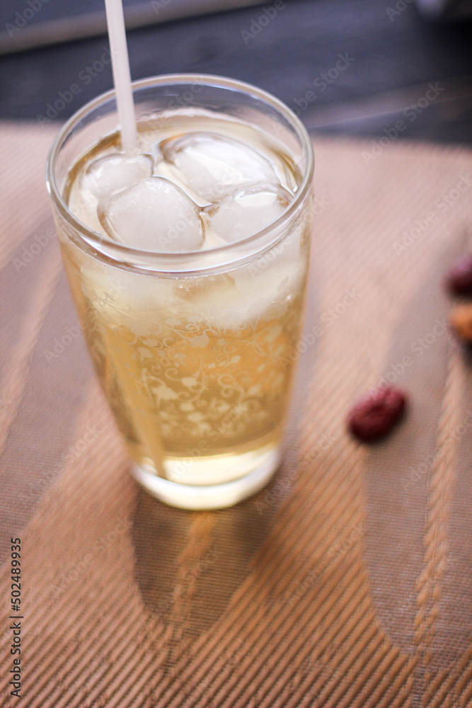 Chrysanthemum Juice, chilled, served in a clear glass placed on a black table Chrysanthemum Juice, chilled, served in a clear glass placed on a black table