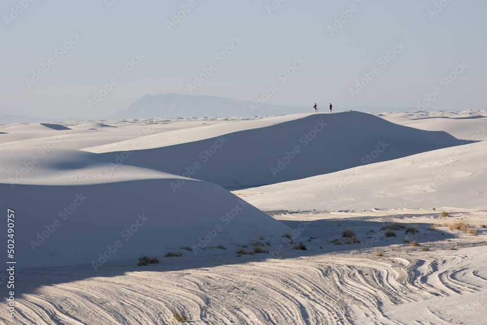 A couple on top of sand dunes in White Sands National Park A couple on top of sand dunes in White Sands National Park