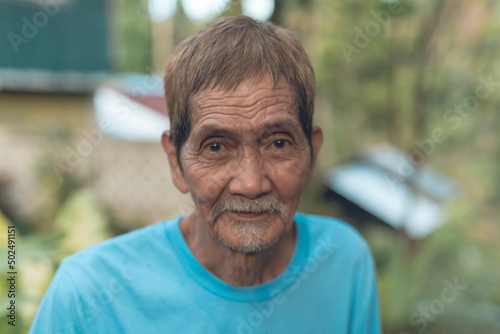 A portrait of a friendly 70 year old Filipino man in a blue shirt. Healthy, fit and active septuagenarian. photo