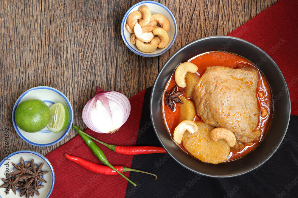 Thai food and Thai muslim food. Chicken Massaman curry with spices on old wood backgroud. Delicious Thai food. Thai food and Thai muslim food. Chicken Massaman curry with spices on old wood backgroud. Delicious Thai food.