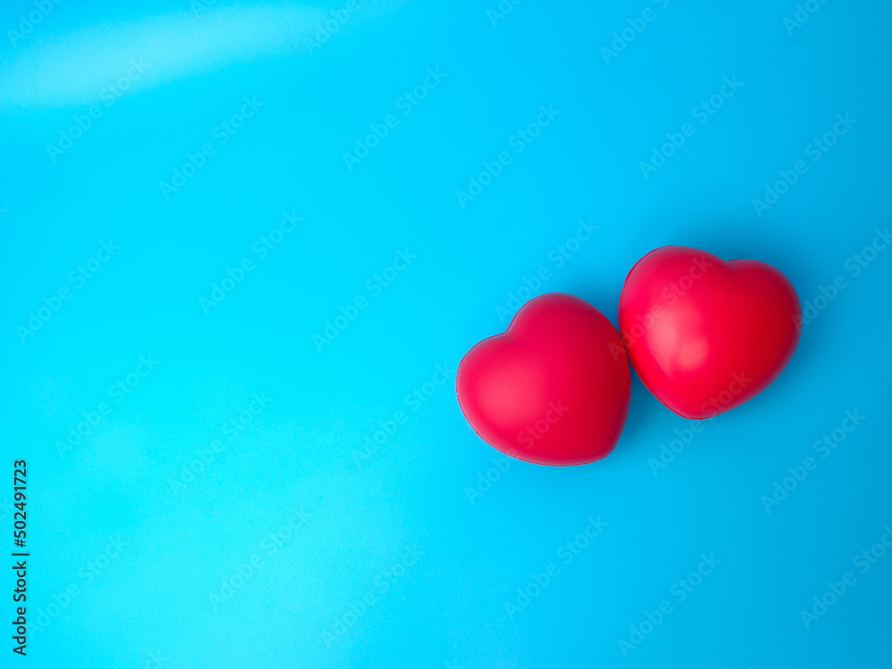 Top view two red heart shape on blue background with copy space. Can use for heart check up or love concept Top view two red heart shape on blue background with copy space. Can use for heart check up or love concept