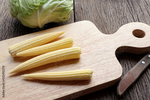 Delicious baby corn, fresh young baby corn on a wooden cutting board on the table.