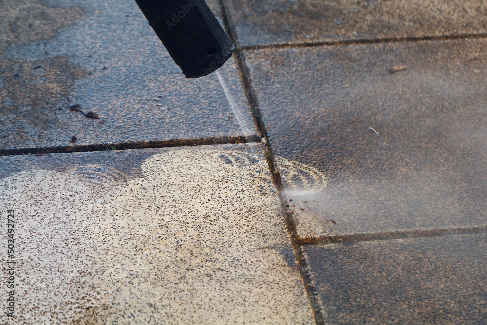 Power cleaning dirty floor, paving slabs with high pressure water jet. Cleaning with high