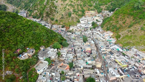 Aerial Slowly Panning Saidpur Village Surrounded By Steep Green Mountains - Islamabad, Pakistan photo