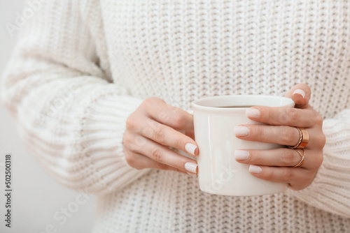 Woman holding cup of coffee, closeup