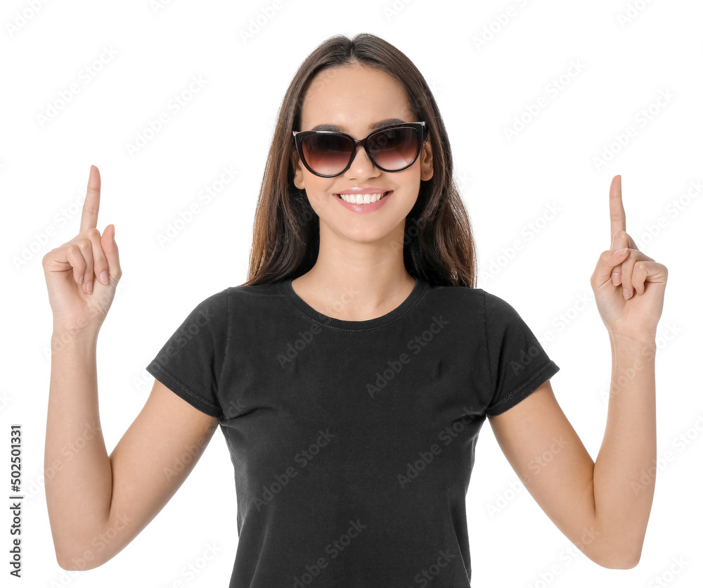 Pretty young woman in stylish t-shirt pointing at something on white background Pretty young woman in stylish t-shirt pointing at something on white background