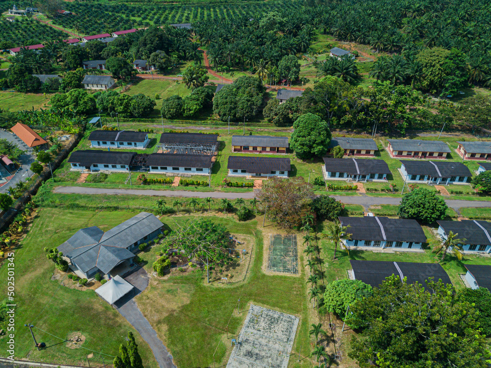 Aerial drone view of workers settlements near oil palm plantations area in Asahan, Melaka, Malaysia.