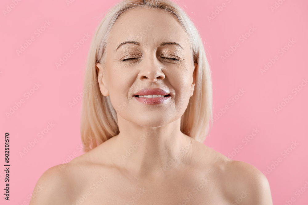 Mature blonde woman with healthy skin on pink background, closeup Mature blonde woman with healthy skin on pink background, closeup