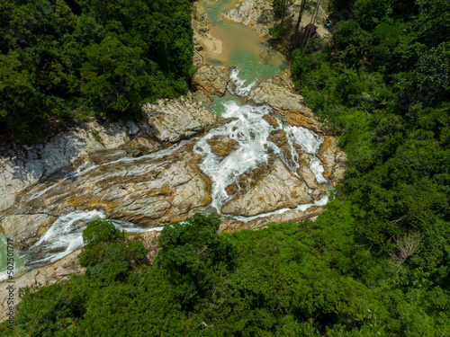 Aerial drone view of falling water from high angle view at Lata Berangin Waterfall, Kuala Krai, Kelantan, Malaysia.