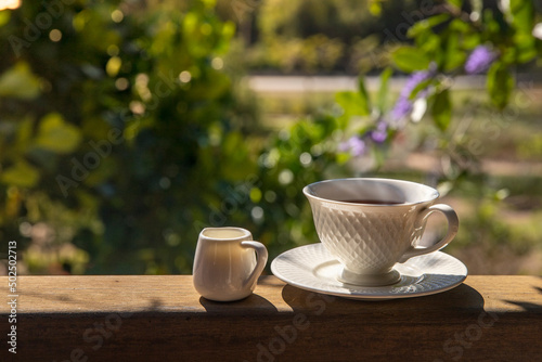 Cup with tea on a table over a mountain landscape with sunligh in morningt. Beauty nature background.