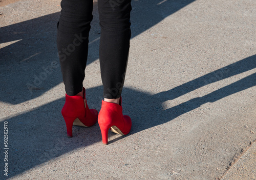 Women's feet in red shoes.