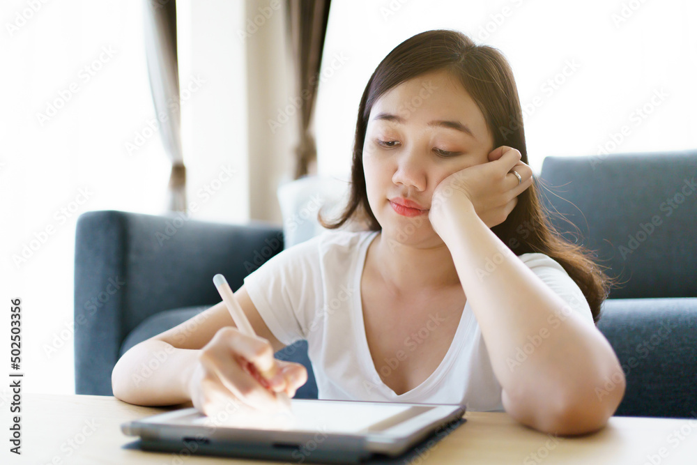 Asian woman using tablet drawing an illustration. Asian woman using tablet drawing an illustration.