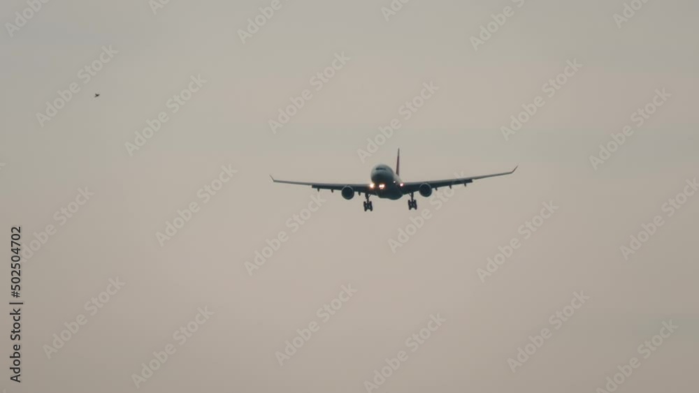 Jet aircraft landing gear and descending for landing at sunset or dawn. Tourism and travel concept Jet aircraft landing gear and descending for landing at sunset or dawn. Tourism and travel concept
