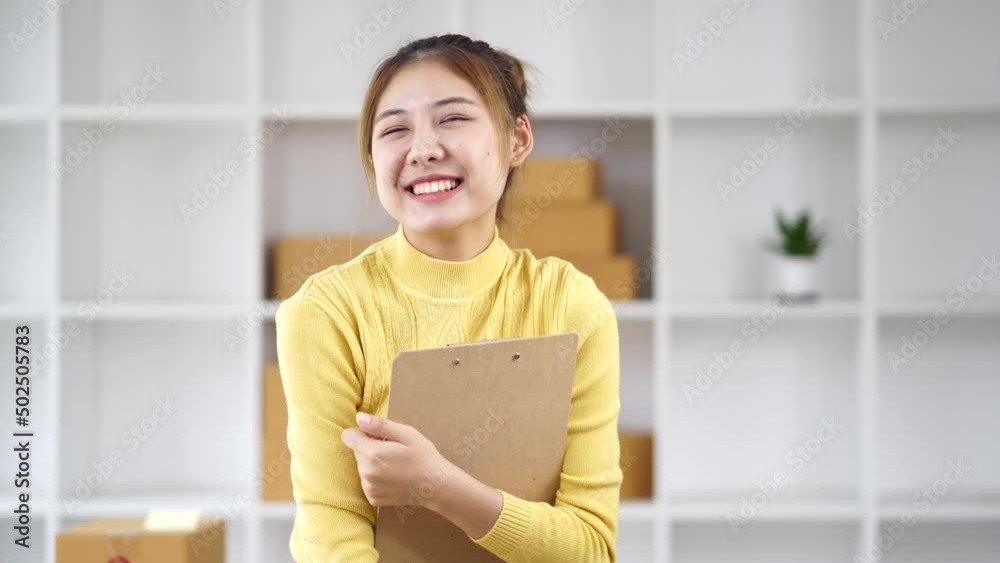 Happy young Asian business owner woman prepare parcel box and check online orders of product for deliver to customer on laptop computer. Shopping Online concept. Happy young Asian business owner woman prepare parcel box and check online orders of product for deliver to customer on laptop computer. Shopping Online concept.