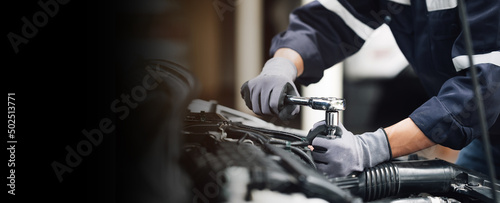 Mechanic works on the engine of the car in the garage. Repair service. Concept of car inspection service and car repair service.