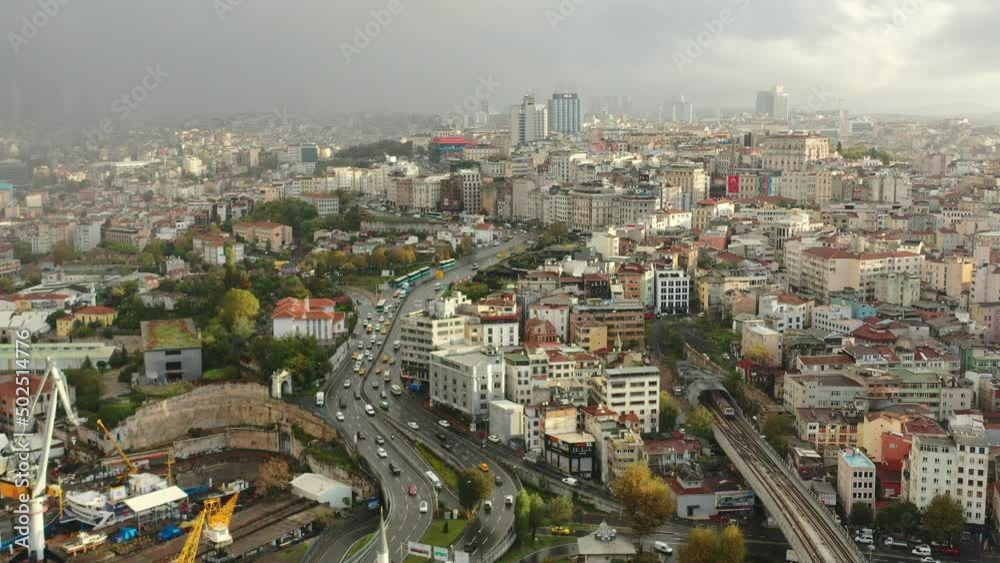 Wide aerial view of highway traffic in Istanbul Turkey next to old European residential buildings at sunrise with a dark thunderstorm clouds and rain in the distance Wide aerial view of highway traffic in Istanbul Turkey next to old European residential buildings at sunrise with a dark thunderstorm clouds and rain in the distance