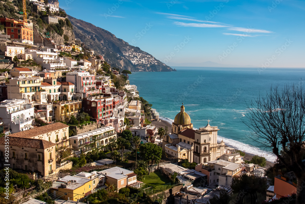 Panoramic view on Santa Maria Assunta church and colorful houses of coastal town Positano, Amalfi Coast, Italy, Campania, Europe. Vacation at coastline at the Mediterranean Sea. Praiano in distance