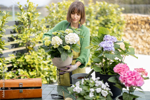 Canvastavla Young woman taking care of flowers in the garden