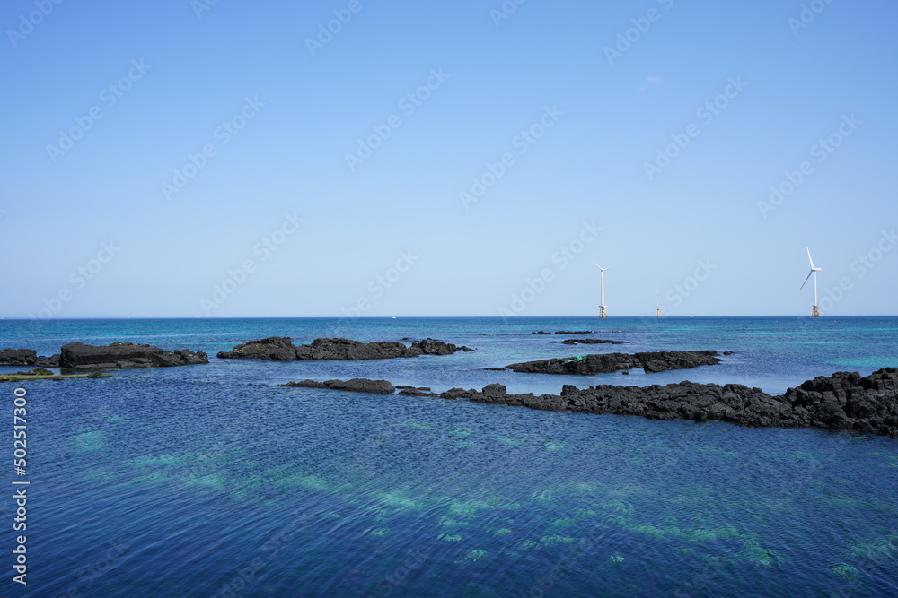 clear shoaling beach and turbines on the sea