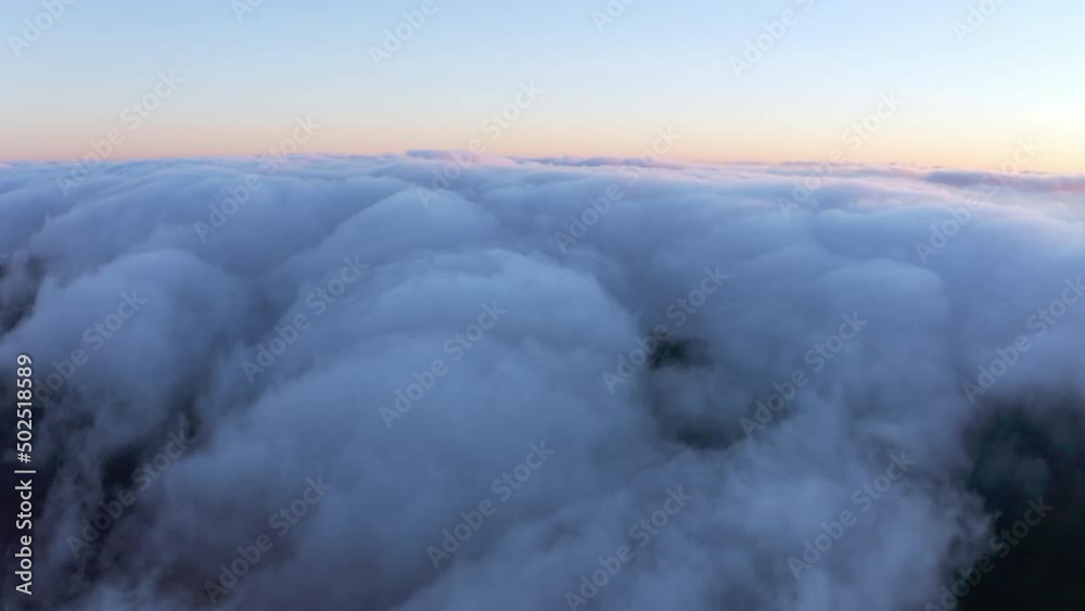 Thick layer of white clouds above mountains at sunrise Thick layer of white clouds above mountains at sunrise