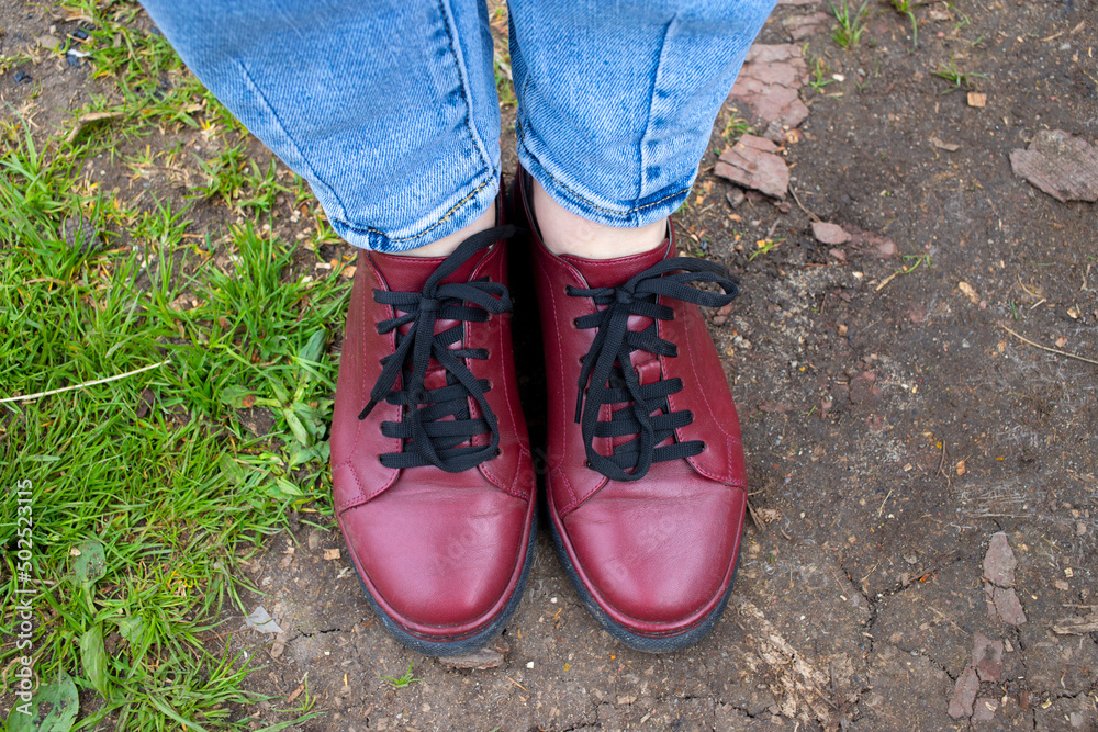 Top view of autumn , summer burgundy women ankle boots on green grass. spring fashion shoes.