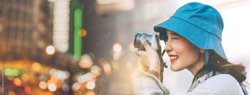 Attractive young adult asian woman traveller using camera for photo journey  banner size background