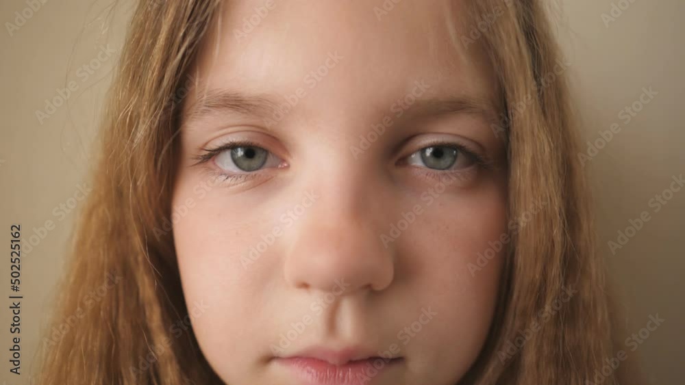 Close up female face of desperate child looking into camera indoor. Disappointed gaze of small upset kid. Portrait of little blonde girl with sorrowful expression inside Close up female face of desperate child looking into camera indoor. Disappointed gaze of small upset kid. Portrait of little blonde girl with sorrowful expression inside