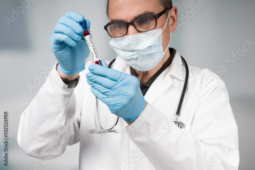 doctor or scientist with a positive coronavirus antibody test tube