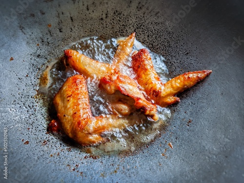 Beautifully colored fried chicken in a pan with hot oil.