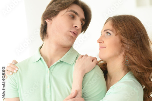 Close up portrait of happy young couple embracing at home