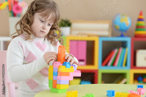 little girl playing with colorful plastic blocks