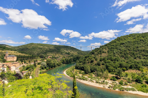 Full of forests and cultivated fields Tarn valley with river spread out under tallest bridge of world - Millau Viaduct. Aveyron, Occitania, France