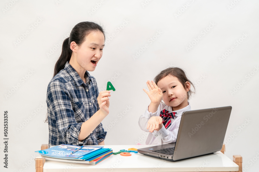 Mother and little girl are learning English letters Mother and little girl are learning English letters