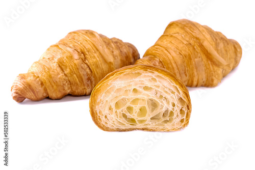 Plain Croissants and cut in half, showing the cross section, a classic crescent-shaped croissant. isolated on a white background.