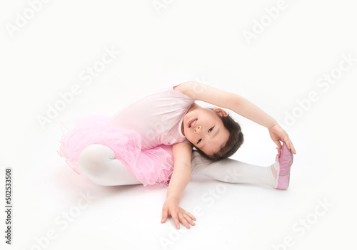 The beautiful little girl is doing gymnastics on a white background