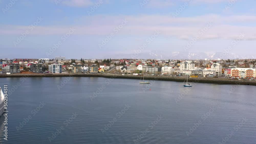 Flying Over The Sea From The Port Towards Waterfront Residential Houses And Buildings. - aerial forward Flying Over The Sea From The Port Towards Waterfront Residential Houses And Buildings. - aerial forward