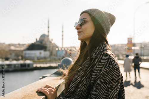 Canvas Print A girl with dark long hair with glasses, a gray hat and a black and white coat