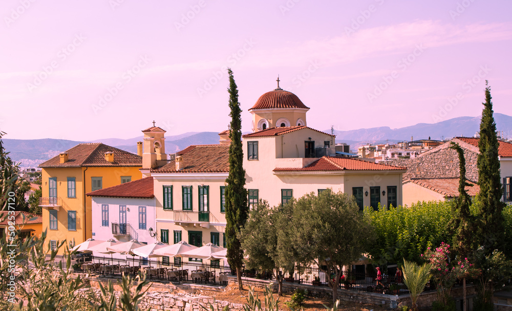 Beautiful greek orthodox church and the city view on the background are mountains and pink sky, Athens, Greece