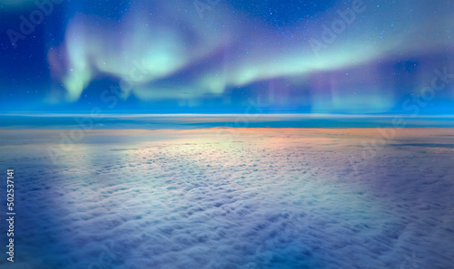 Northern lights or Aurora borealis in the sky over the clouds 