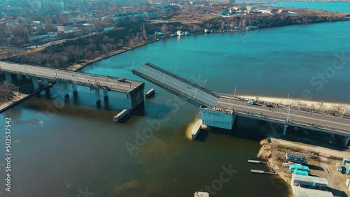 Lowering of upper part drawbridge over the river Nikolaev Ukraine few days before start of armored invasion. Logistics concept of water cargo transportation photo