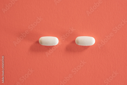 Still life of with pills on red background.