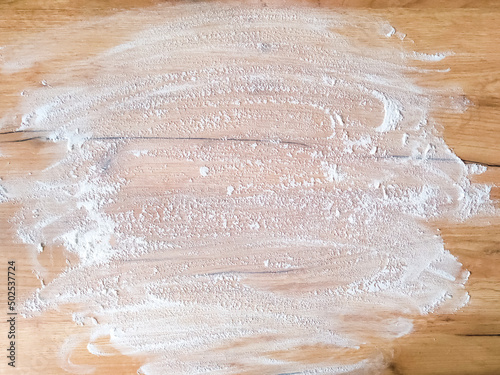 White flour on wooden table. Free space for text. View from above. Top view