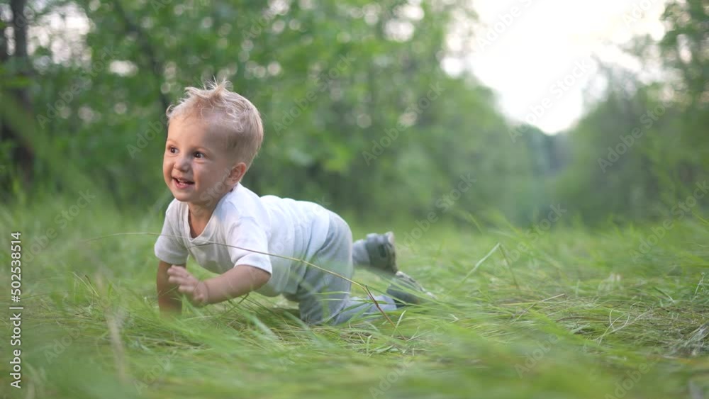 little baby boy crawling a on the grass in the park. happy family kid dream concept. little boy fun baby crawling outdoors in the park playing. happy family childhood concept little baby boy crawling a on the grass in the park. happy family kid dream concept. little boy fun baby crawling outdoors in the park playing. happy family childhood concept