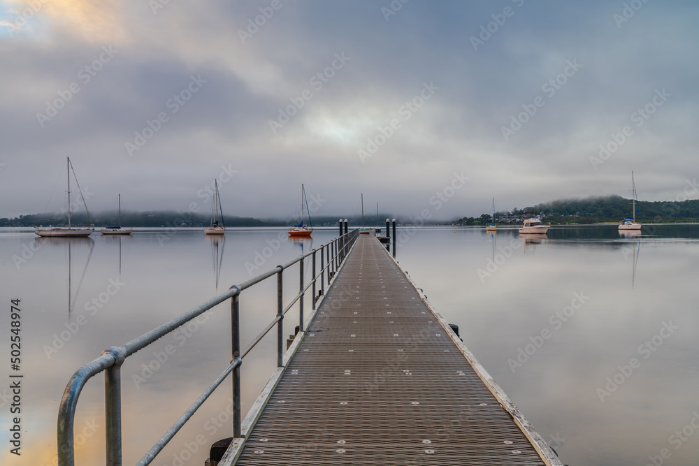 Boats and wharf on a foggy morning
