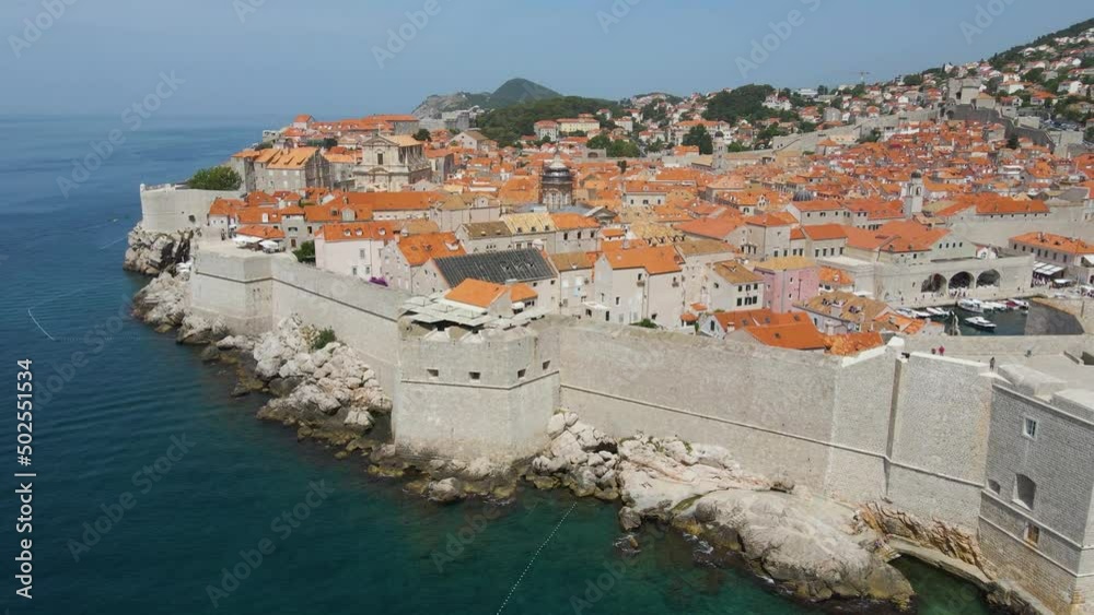 Aerial drone rotating shot over the old fortress along the old town of Dubrovnik, Croatia with the view of building rooftops on a sunny day. Aerial drone rotating shot over the old fortress along the old town of Dubrovnik, Croatia with the view of building rooftops on a sunny day.