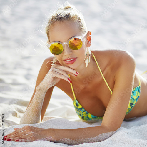 Woman in sunglasses lying on the beach - close up