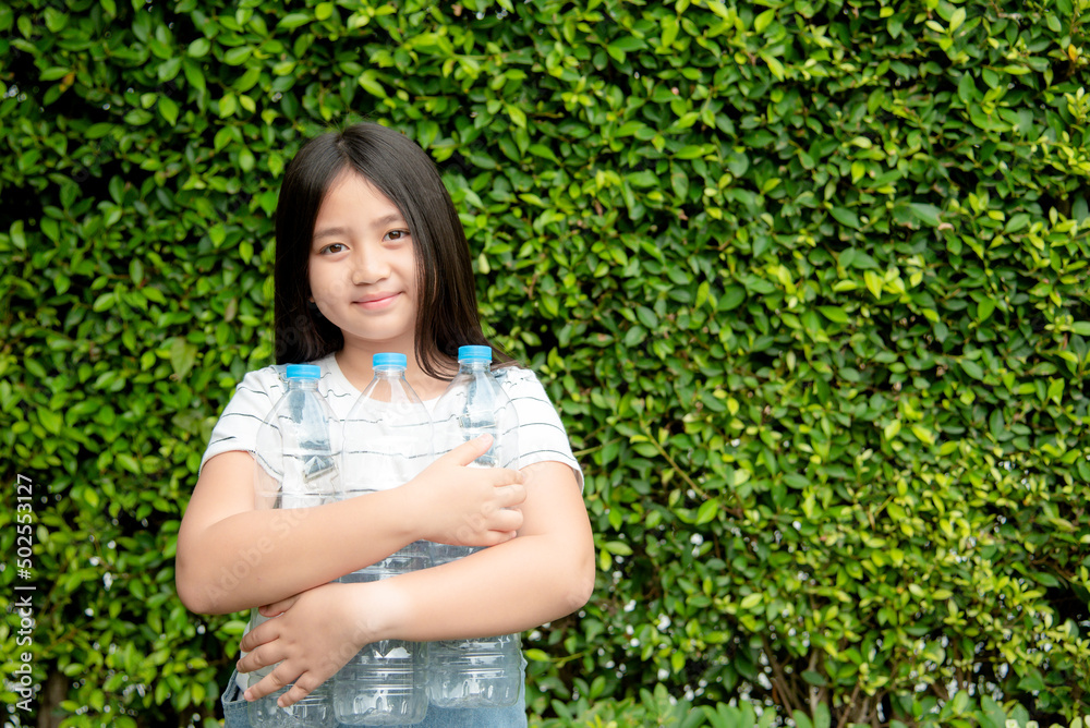 Girls collect plastic bottles for recycling. She holds a plastic bottle.Save world sustainability. Girls collect plastic bottles for recycling. She holds a plastic bottle.Save world sustainability.